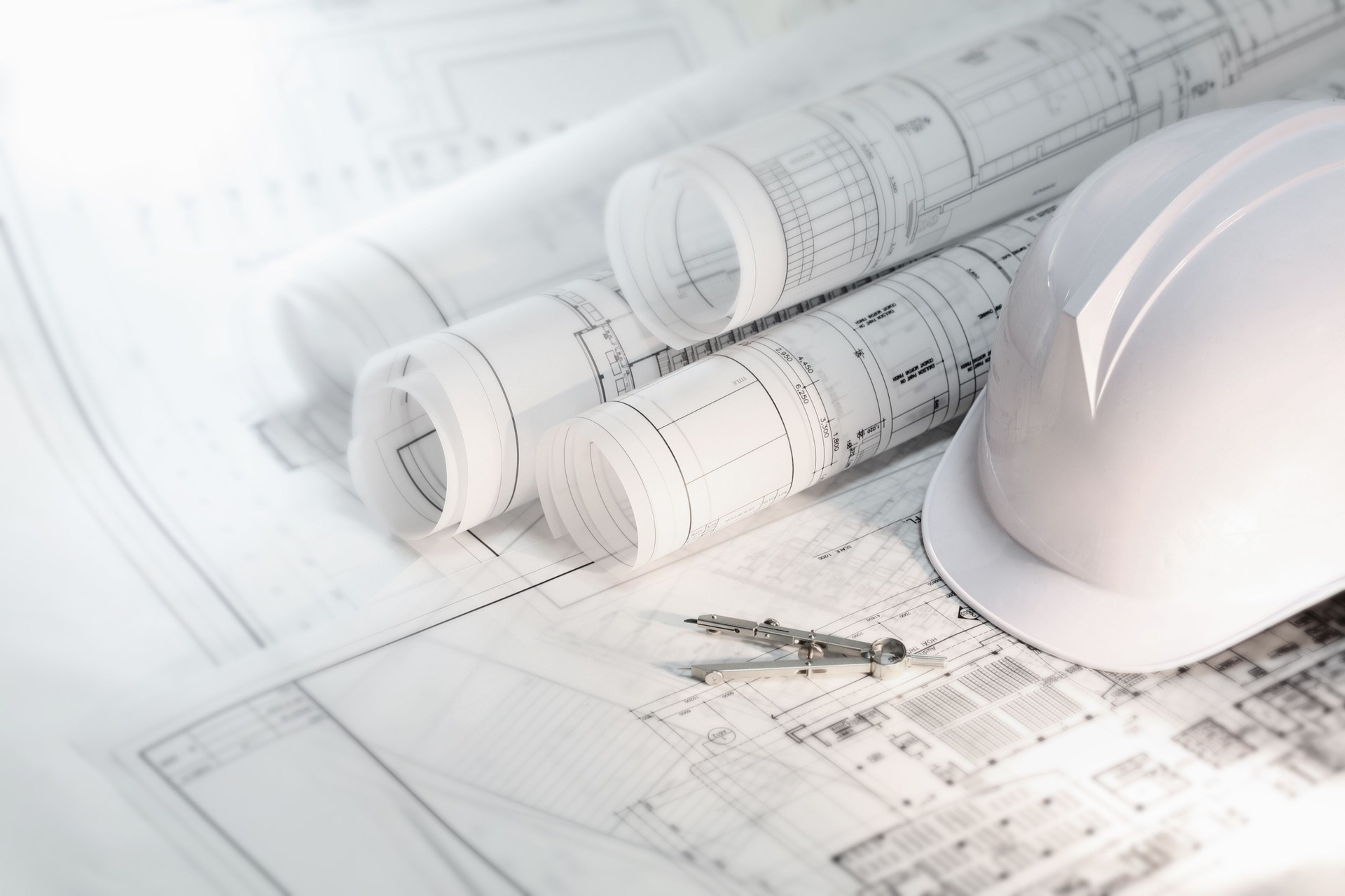 Hard hat and compass on architectural blueprints and construction technology and future industry Hard hat and compass on architectural blueprints and construction technology and future industry